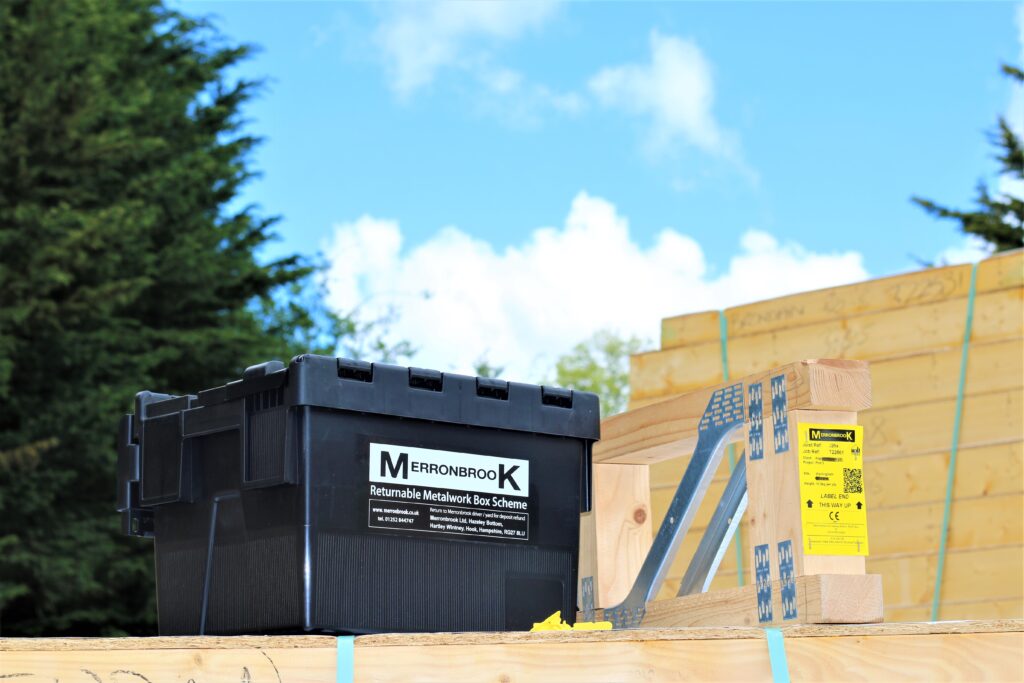 An outdoor scene with Merronbrook branded tool box and a palette of typical supplies for a UK timber frame manufacturer.